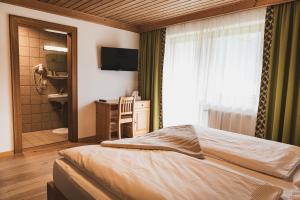una camera con letto e un bagno con televisore di Gästehaus Einödberg a Mittersill