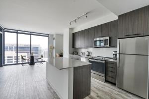 a kitchen with stainless steel appliances and a large window at Blueground Downtown gym deck pool nr dining ATX-255 in Austin