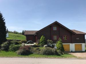 a large brown house with a white garage at Chalet familial à Vagney + Jardin et Terrain de Bowling in Vagney