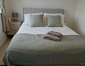 - un grand lit avec une couverture et des oreillers dans l'établissement Village Home -Syston, Leicestershire, à Syston