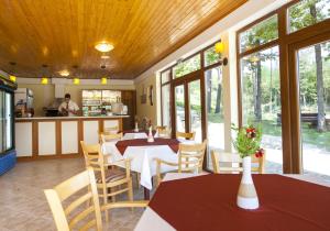 a dining room with tables and chairs and a kitchen at Relax Coop Hotel in Voneshta Voda