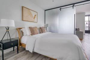 a white bedroom with a large bed and a lamp at Blueground Downtown gym pool nr restaurants ATX-254 in Austin +32 photos