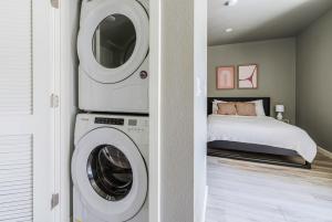 a laundry room with a washer and dryer next to a bed at Blueground Oakland wd nr bakeries bars SFO-1717 in Oakland