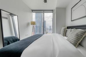 a white bedroom with a large bed and a window at Blueground Downtown pool lounge gym nr shops ATX-257 in Austin +39 photos