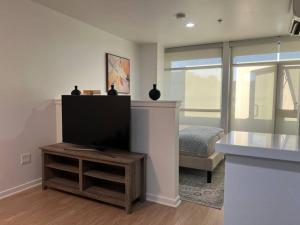 uma sala de estar com uma televisão de ecrã plano e uma cama em Seaside Retreat in Santa Monica, steps to the beach, free parking em Los Angeles