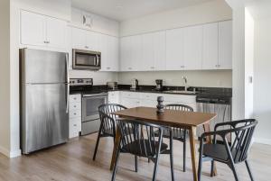 a kitchen with a table and chairs and a refrigerator at Blueground Oakland roof lounge near dining SFO-1718 in Oakland