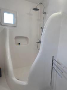 a white tub in a bathroom with a window at Anastasis Wind Mill in Mármara +14 photos