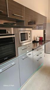 una cocina con electrodomésticos de acero inoxidable y armarios de madera en Villa Ayada, en Marrakech