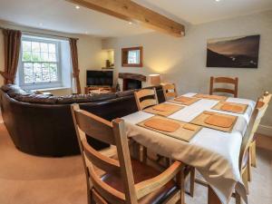 - une salle à manger avec une table et un canapé dans l'établissement Argyle Cottage, à Ambleside