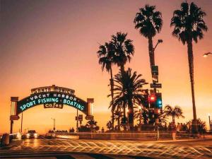 uma rua com palmeiras e um semáforo em Seaside Retreat in Santa Monica, steps to the beach, free parking em Los Angeles