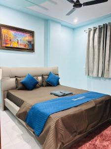 1 dormitorio con 1 cama grande y paredes azules en Roomshala 177 Homestay Thehrav - Near Delhi Cantt Railway Station, en Nueva Delhi