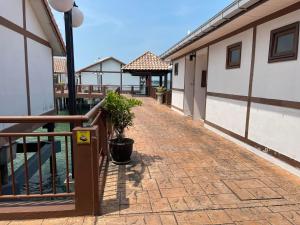 a brick walkway next to a building with a porch at Cuti-cuti port dickson water chalet in Port Dickson