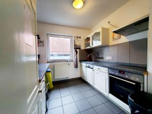 a small kitchen with white cabinets and a window at Monteurhaus in Heidenheim in Heidenheim an der Brenz