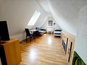 a attic room with a table and chairs and a window at Monteurhaus in Heidenheim in Heidenheim an der Brenz