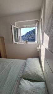 Habitación pequeña con cama y ventana en Apartman Bačarije,Pag-Prizna en Seline