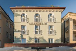 een wit gebouw met een bord erop bij Hotel Giardinetto in Garda