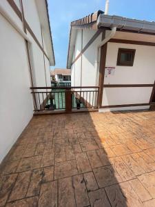 a balcony of a house with a brick floor at Cuti-cuti port dickson water chalet in Port Dickson