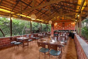 a restaurant with tables and chairs and a bar at Keys Lite by Lemon Tree Hotels Sylvan, Dapoli in Dapoli