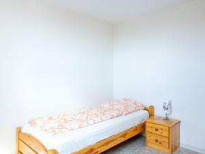 a bed with a wooden frame and a night stand at Delightful holiday home in Battenberg near forest in Battenberg