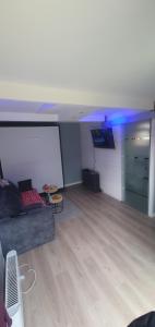 a living room with a couch and a white screen at CozyCube Paris in Vitry-sur-Seine +13 photos