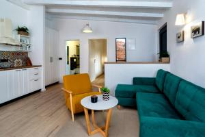 a living room with a green couch and a table at Garden House Rovinj in Rovinj +4 photos
