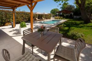 a patio with a table and chairs and a pool at Garden House Rovinj in Rovinj