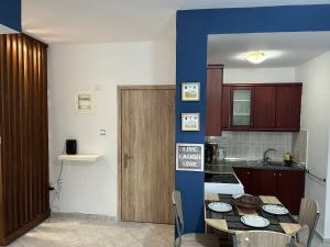 a kitchen with a table and a blue wall at Dimitris Flat in Neoi Epivates