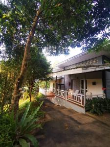 a house with a tree in front of it at Bangnu Greenery Resort in Takua Thung