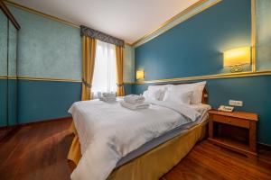 a blue bedroom with a bed with towels on it at Hotel Kinsky Fountain in Prague