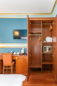 a room with a bed and a desk with a microwave at Hotel Kinsky Fountain in Prague
