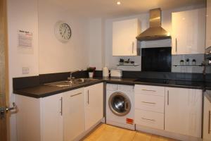 a kitchen with a sink and a washing machine at The Elm @ Short Stays in Basingstoke