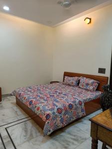 1 dormitorio con 1 cama con un edredón colorido en Homestay in Connaught Place, en Nueva Delhi