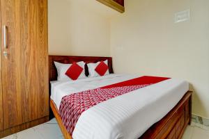 a bedroom with a bed with red and white sheets at Mm Home Stays in Irugūr