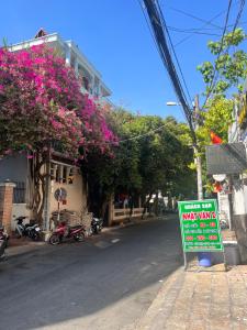 un cartel al lado de una calle con flores en Nhật Vân 2 en Ho Chi Minh