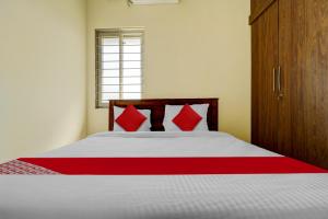1 dormitorio con 1 cama grande con almohadas rojas en Mm Home Stays en Irugūr