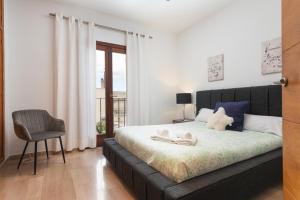 a bedroom with a bed with a chair and a window at Can Joan -Maria- in Maria de la Salut +43 photos