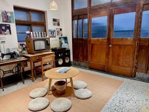 un soggiorno con porta in legno e tavolo di 東衛參捌 陶藝旅店 a Magong