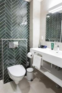 a bathroom with a toilet and a sink and a mirror at Hotel Sofia in Helsinki