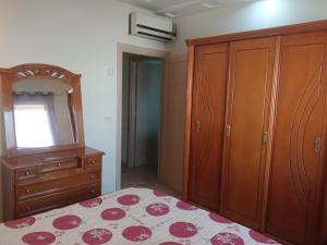 - une chambre avec un lit, une commode et un miroir dans l'établissement Paradise Days, à Sfax