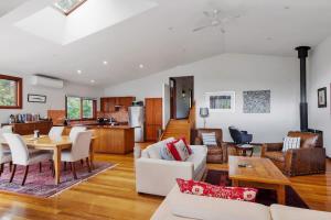 a living room with white furniture and a kitchen at Mountain Home Leura - Perfect Weekend Escape in Leura