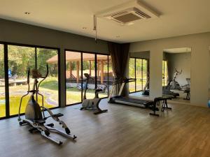 a gym with treadmills and exercise bikes in a room at Tusita Wellness Resort in Paktako