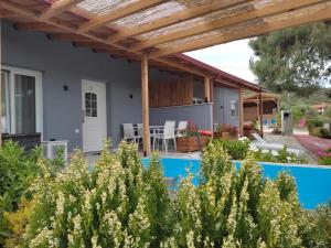 Blick auf ein Haus mit einer hölzernen Pergola in der Unterkunft Pefkari Bay Villas in Pefkari