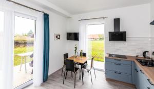 a kitchen and dining room with a table and chairs at Vinorell Apartman in Etyek