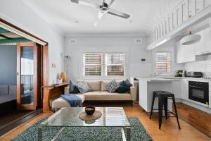 uma sala de estar com um sofá e uma mesa em Relaxed Clovelly Beach Home - Parking - Cloey6 em Sydney