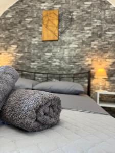 a bedroom with two beds and a stone wall at Cueva Con Vista Studios in Pirgos