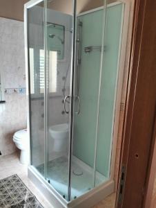 ジャルディーニ・ナクソスにあるCasa le Palmeのバスルーム(ガラス張りのシャワー、トイレ付)