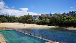 uma vista para uma praia com pessoas na areia em Relaxed Clovelly Beach Home - Parking - Cloey6 em Sydney