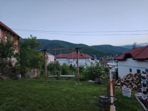 Blick auf einen Hof mit Häusern und Bergen in der Unterkunft Apartmani Ruj in Sokobanja