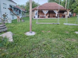 a yard with swings in front of a house at Apartmani Ruj in Soko Banja