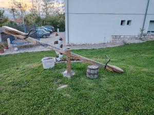 un poteau et des tonneaux en bois dans l'herbe dans l'établissement Apartmani Ruj, à Sokobanja